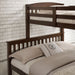 Left facing close up of the headboards of a Mission style twin-over-full merlot wood bunk bed in a room with linens