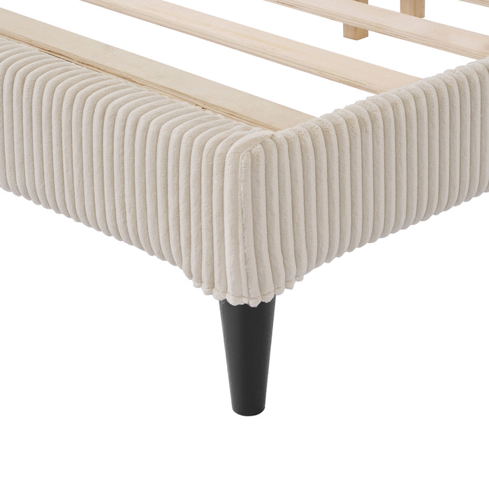 Left facing close up view of the footboard corner and leg of a modern ivory corduroy channel tufted headboard queen platform bed on a white background