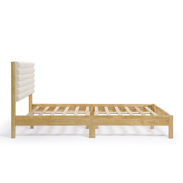 Front facing side view of a modern wood frame queen platform bed with a channel tufted upholstered white boucle headboard on a white background