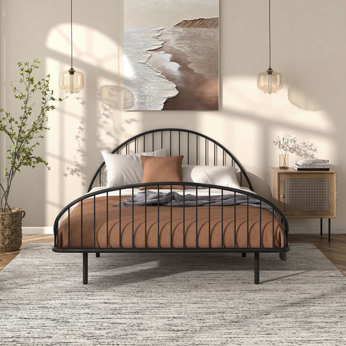 Front facing industrial black metal full bed frame with rounded head and footboards in a room with linens and accessories