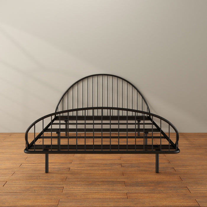 Front facing industrial black metal full bed frame with rounded head and footboards in a room with a wood floor