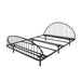 Left facing industrial black metal queen bed frame with rounded head and footboards on a white background