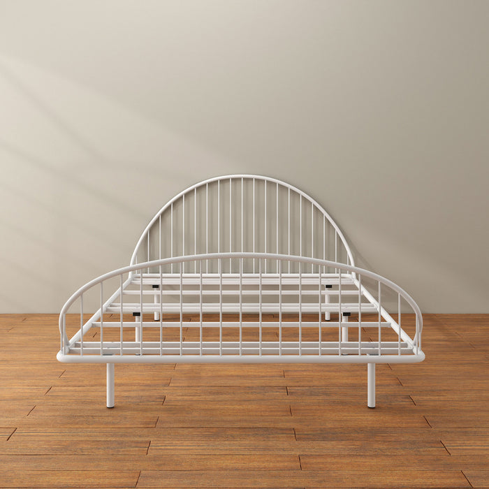 Front facing industrial white metal full bed frame with rounded head and footboards in a room with a wood floor