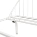 Left facing close up view of the headboard of an industrial white metal queen bed frame with rounded head and footboards on a white background