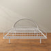 Front facing industrial white metal queen bed frame with rounded head and footboards in a room with a wood floor