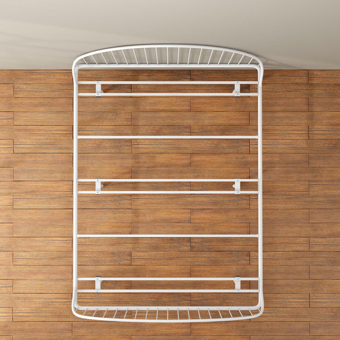 Front facing overhead view of an industrial white metal queen bed frame with rounded head and footboards in a room with a wood floor