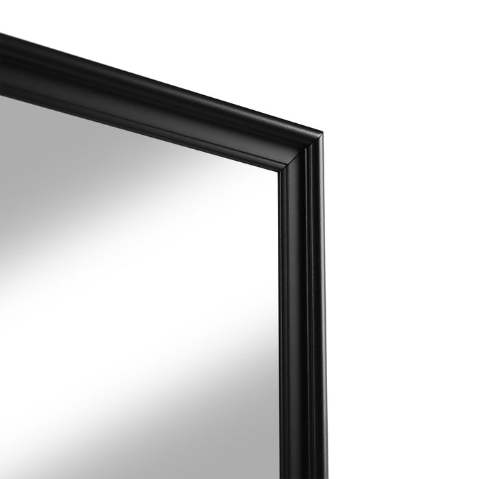 Right facing close up of a traditional black finish solid wood six-drawer dresser with a framed mirror showing its framed mirror on a white background