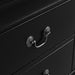 Right facing close up view of a traditional black finish solid wood two-drawer nightstand showing its antique hanging pulls, on a white background