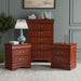 Three-piece traditional cherry finish bedroom set that includes (1) five-drawer chest and (2) two-drawer nightstands in a room with accessories