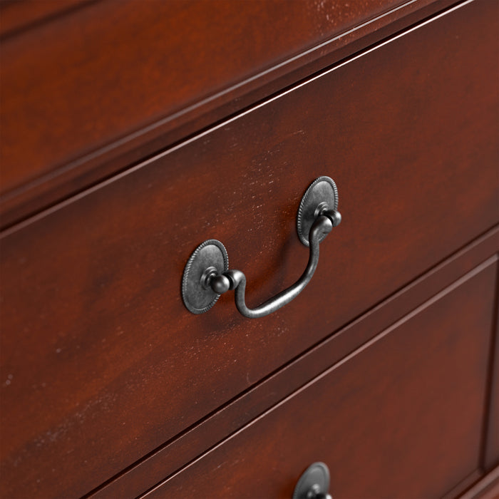 Right facing close up of a traditional cherry finish solid wood two-drawer nightstand showing its hanging drawer pull design