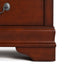 Front facing close up of a traditional cherry finish solid wood five-drawer chest showing its lower molded trim and bracket foot, on a white background