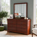 Left facing traditional cherry finish solid wood six-drawer dresser with a framed mirror in a room with accessories