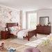 Right facing four-piece traditional cherry finish solid wood full bedroom set with (1) full sleigh bed, (1) two-drawer nightstand, (1) six-drawer dresser, and (1) mirror in a room with linens and accessories