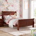 Right facing traditional cherry finish solid wood full sleigh bed in a room with linens and accessories