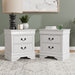 Set of two traditional white finish solid wood two-drawer nightstands in a room with accessories