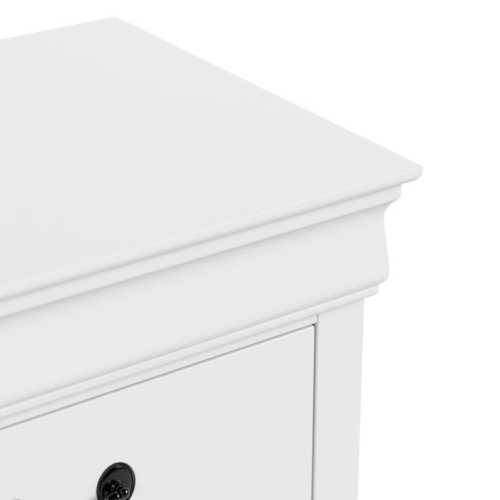 Right facing close up of a traditional white finish solid wood five-drawer chest showing its molded trim and tabletop, on a white background