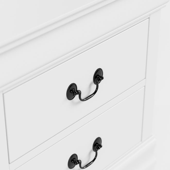 Right facing close up of a traditional white finish solid wood five-drawer chest showing its hanging drawer pulls