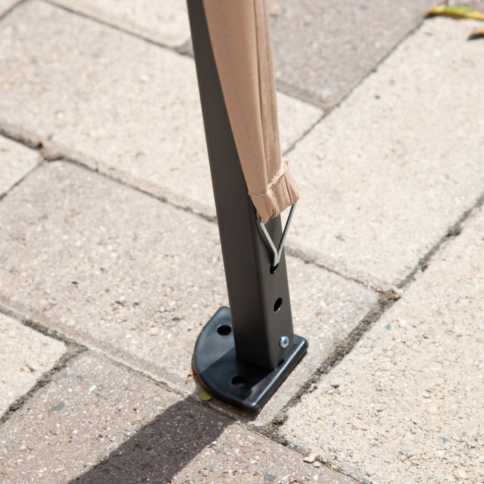 Close up view of the support leg of a modern beige portable camping gazebo canopy with roof and anchors on patio paver stones