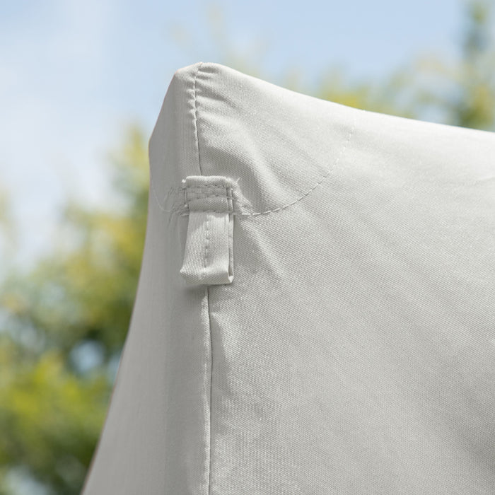 Close up view of the corner of a modern white portable camping gazebo canopy with roof and anchors on an outdoor sky background