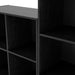 Close up view of a modern black modular bookcase system with open shelving on a white background