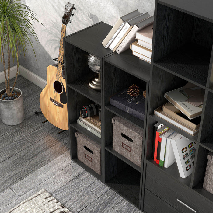 Left facing high-camera view of a durable modern three-shelf slim black storage bookcase in a larger modular configuration in a room with accessories