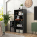 Left facing durable modern four-shelf black storage bookcase in a room with accessories