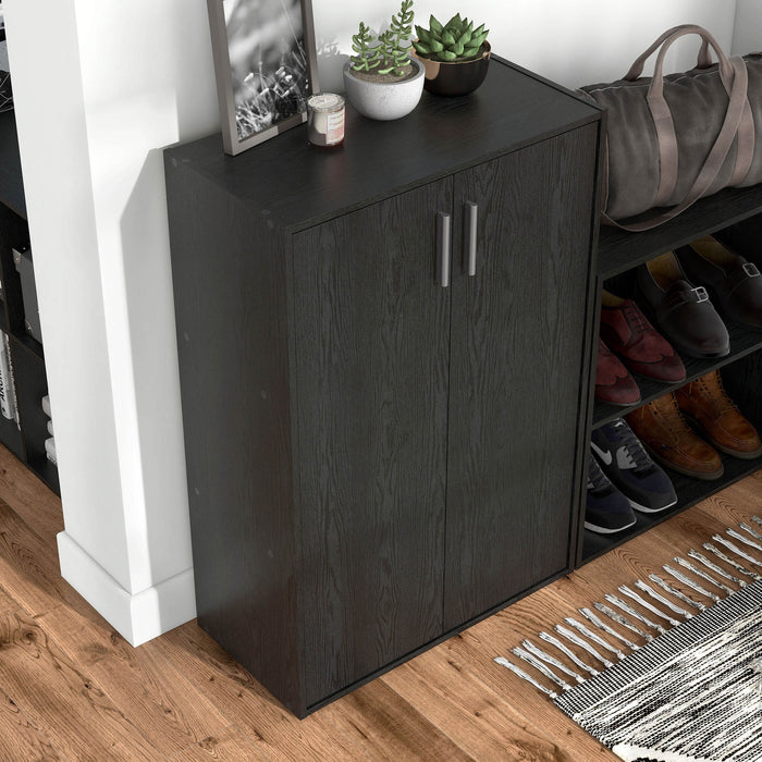 Right facing high-camera view of a durable modern two-door black storage cabinet with silver handles as part of a larger modular configuration in a room with accessories