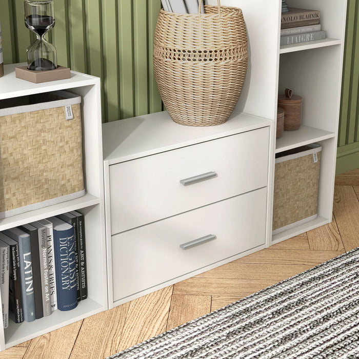 Right facing modern two-drawer white storage cabinet with silver handles in a larger modular bookcase with accessories