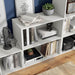 Right facing high-camera view of a durable modern two-shelf white storage bookcase in a larger modular configuration in a room with accessories