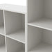 Left facing close up view of a durable modern three-shelf slim white storage bookcase on a white background