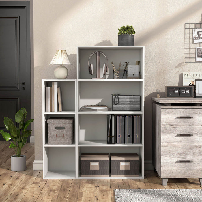 Front facing durable modern four-shelf white storage bookcase in a larger modular configuration in a room with accessories