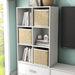 Left facing durable modern six-cubby white storage bookcase as part of a larger modular configuration in a room with accessories