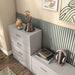 Left facing high-camera view of a modern two-drawer taupe grey storage cabinet with silver handles in a larger modular bookcase with accessories