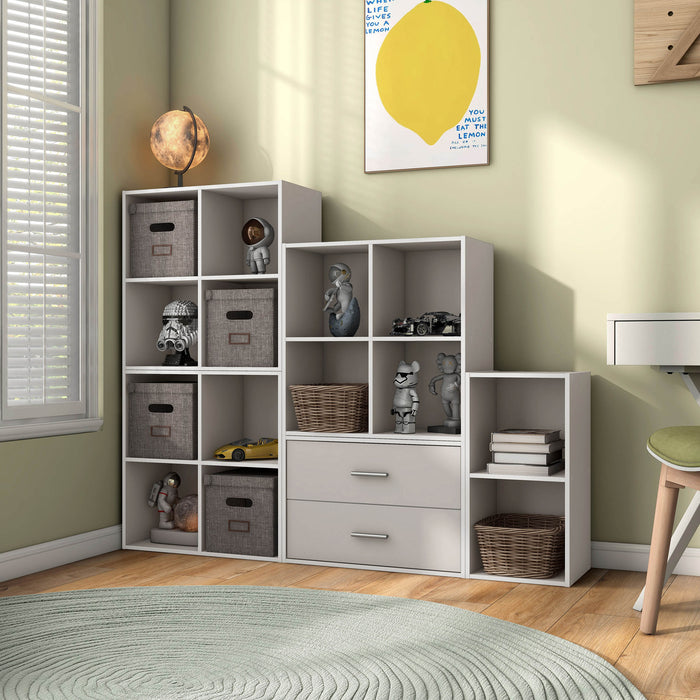 Left facing durable modern four-cubby taupe grey storage bookcase as part of a larger modular configuration in a room with accessories