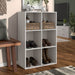 Right facing durable modern six-cubby taupe grey storage bookcase in a room with accessories