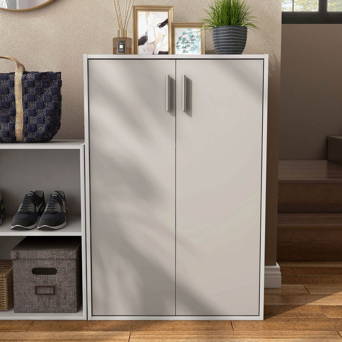 Front facing durable modern two-door taupe grey storage cabinet with silver handles as part of a larger modular configuration in a room with accessories