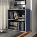 Left facing durable modern two-shelf steel blue storage bookcase in a larger modular configuration in a room with accessories