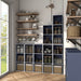 Left facing durable modern three-shelf slim steel blue storage bookcase in a larger modular configuration in a room with accessories