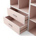 Left facing modern two-drawer light pink storage cabinet with silver handles and drawers open in a larger modular bookcase on a white background