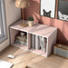 Left facing high-camera view of a durable modern two-shelf slim light pink bookcase in a room with accessories