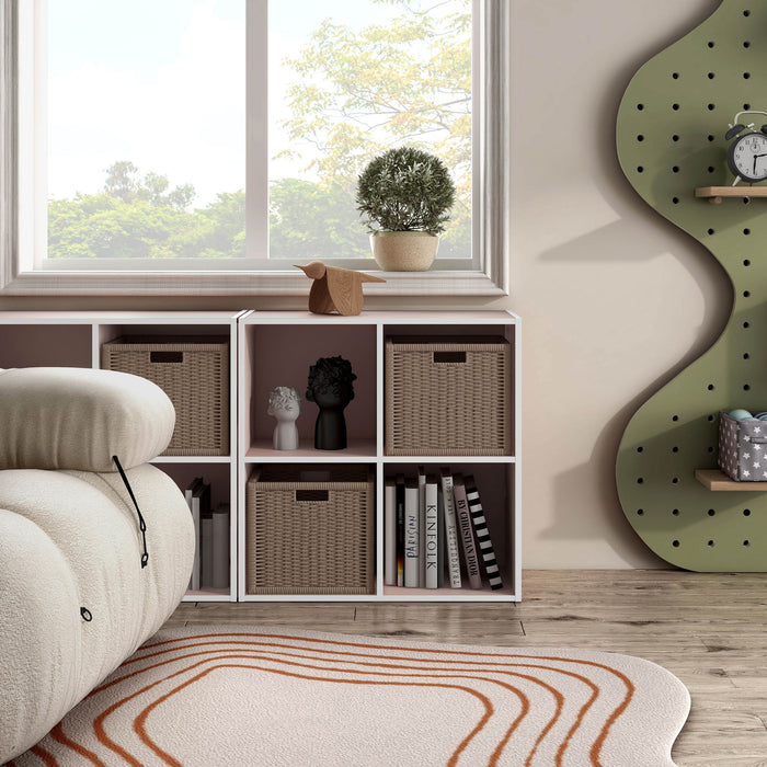 Front facing durable modern four-cubby light pink storage bookcase as part of a larger modular configuration in a room with accessories