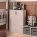 Left facing durable modern two-door light pink storage cabinet with silver handles as part of a larger modular configuration in a room with accessories