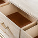 Left facing close up of open drawers on a transitional light oak seven-drawer dresser and mirror with a metal base, on a white background