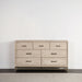 Front facing transitional light oak seven-drawer dresser with a metal base in a room