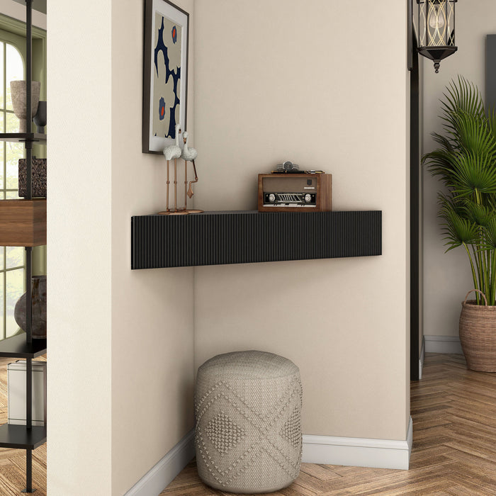 Right facing transitional black wall-mount media console with a wavy front design in a room with accessories