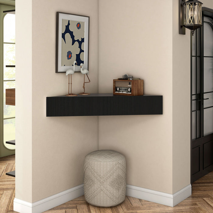 Front facing transitional black wall-mount media console with a wavy front design in a room with accessories